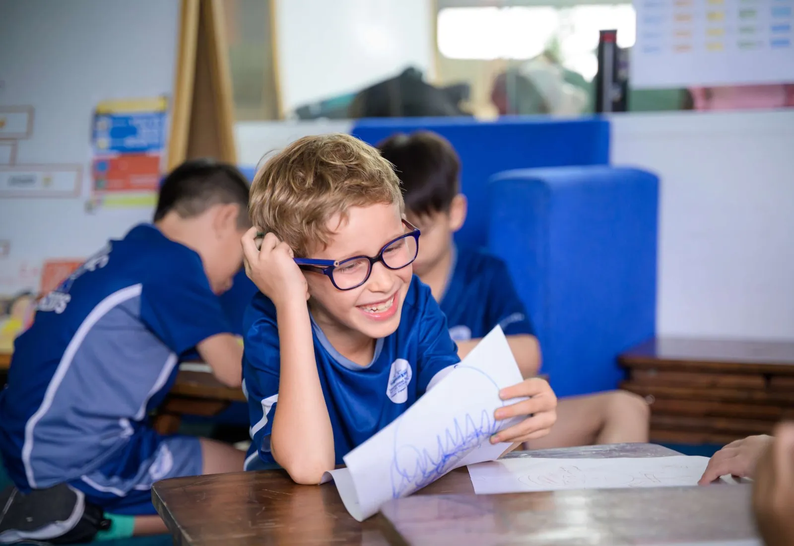 ISHCMC Academic Excellence A student with glasses on enjoying his studies