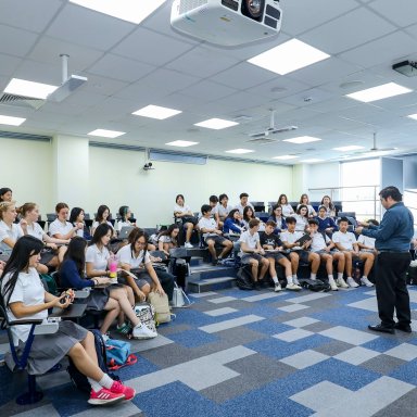 Secondary students sit in a lecture theatre