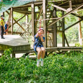 A student rides a zipline