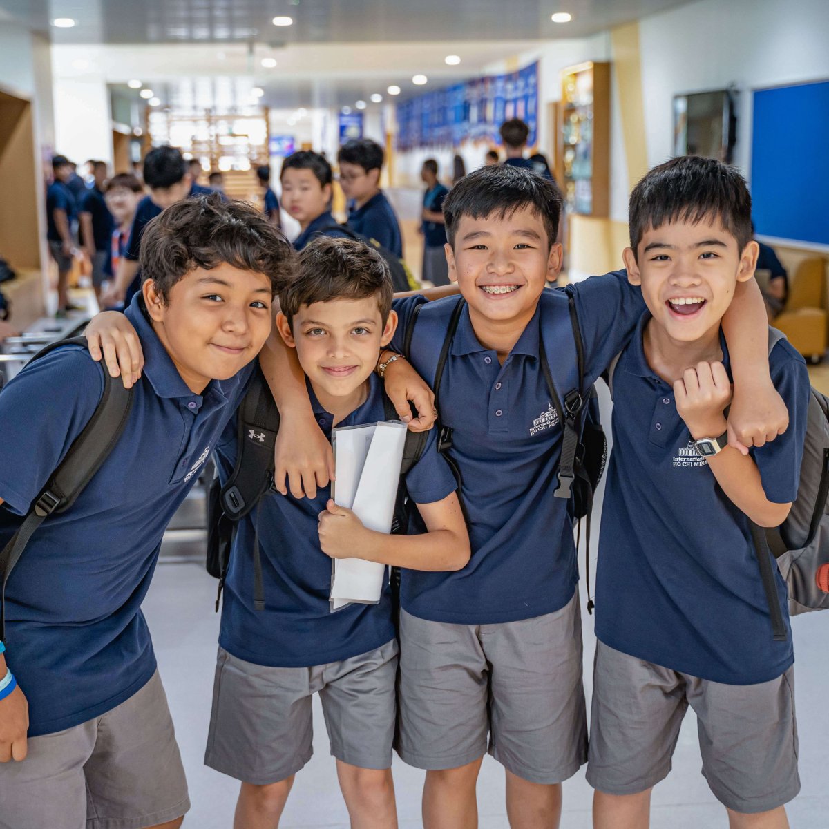 Four middle school students smiling in the school halls