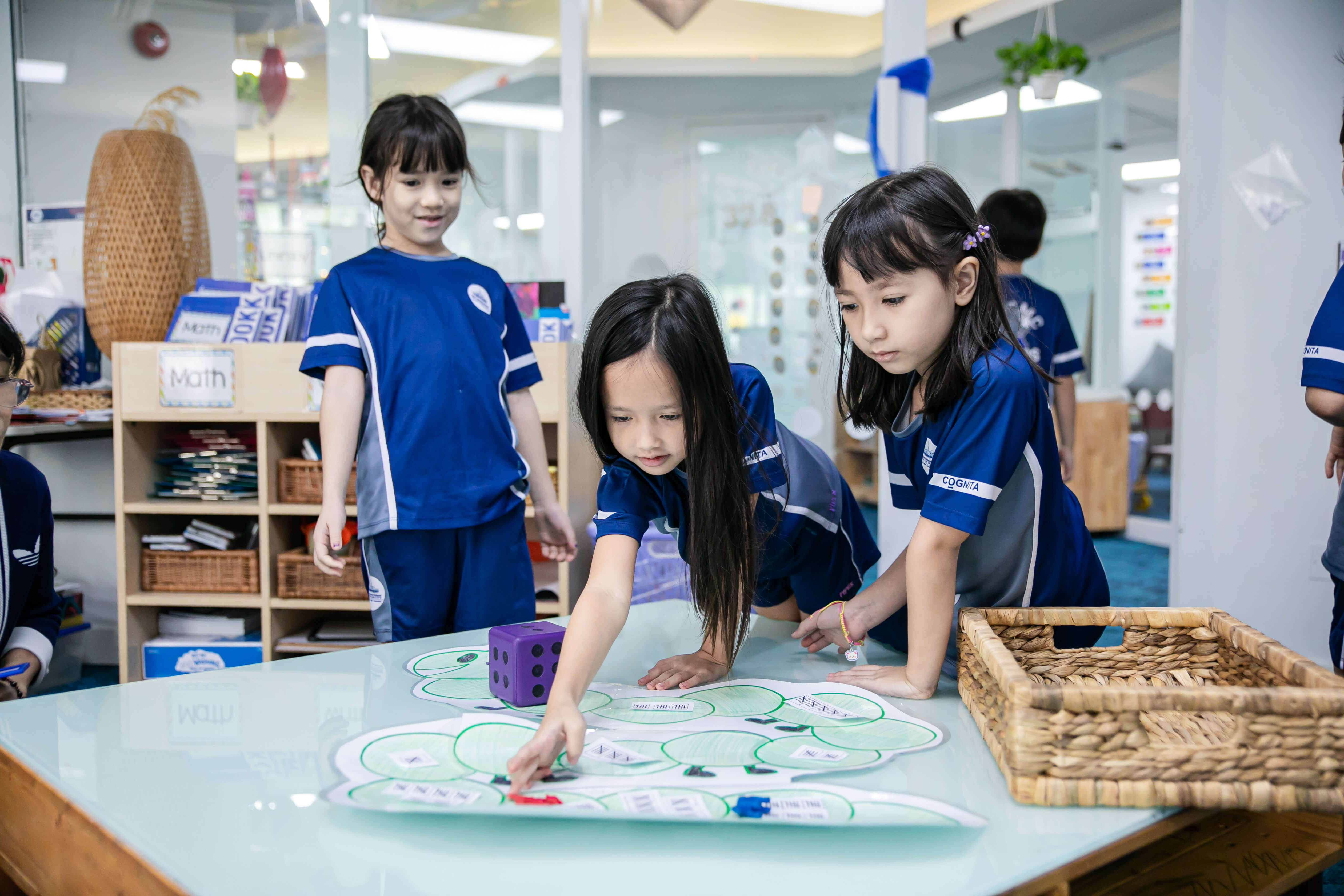 Three students standing around a table learning