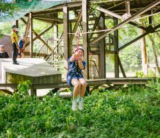 A student rides a zipline