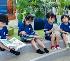 Primary students sitting outside reading